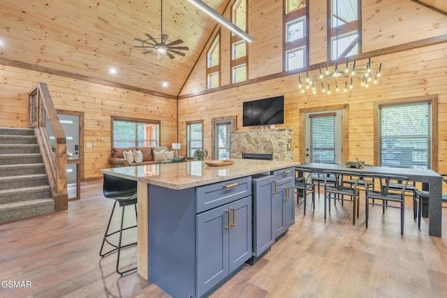 kitchen with open floor plan, a kitchen island, and wood walls