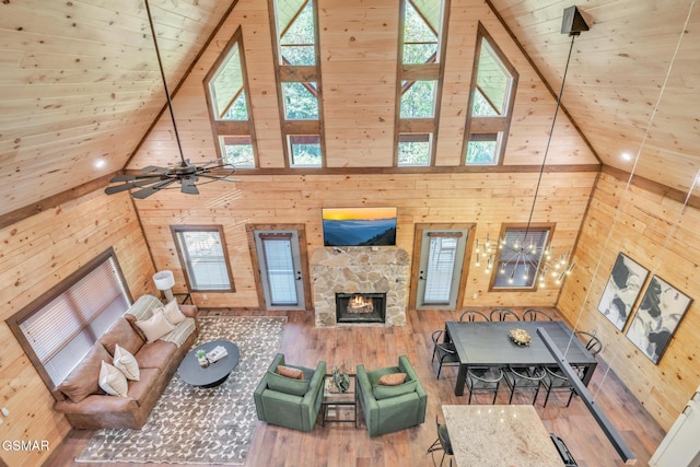 living room with wood ceiling, a fireplace, wood walls, and wood finished floors