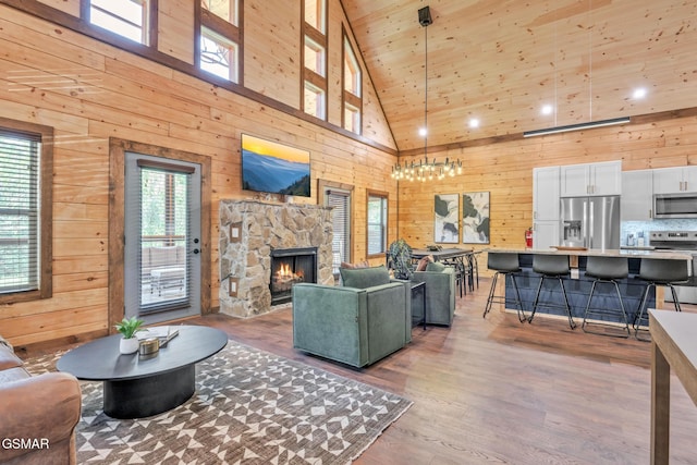 living area featuring a fireplace, wood walls, and wood finished floors