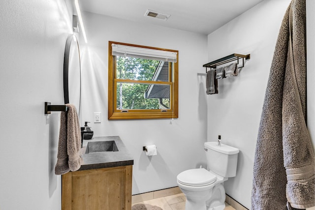 bathroom featuring tile patterned flooring, vanity, and toilet