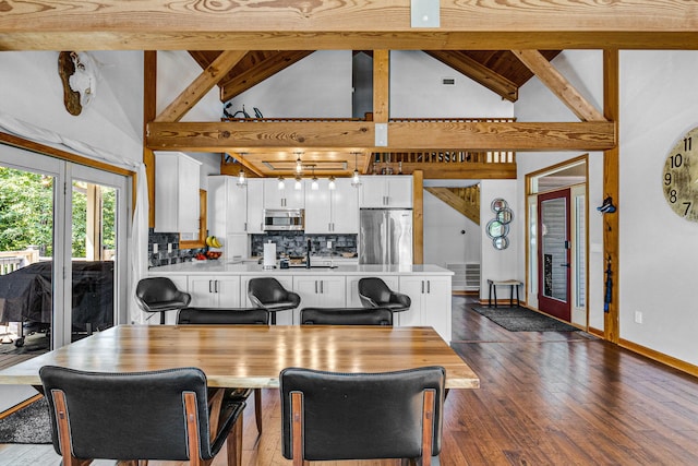 dining area featuring beam ceiling, dark hardwood / wood-style floors, high vaulted ceiling, and french doors