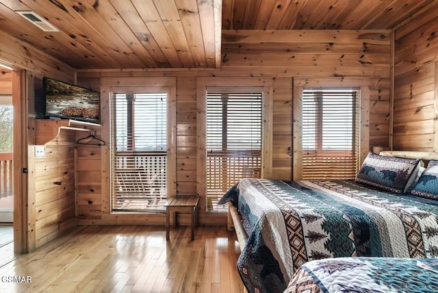 bedroom with wood ceiling, wooden walls, and hardwood / wood-style flooring