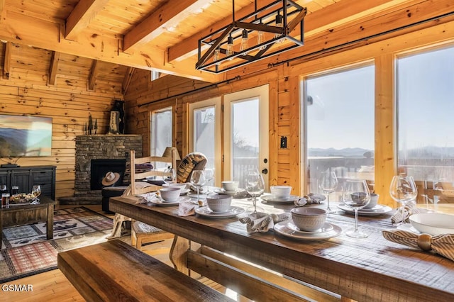 dining area featuring wood walls, wood ceiling, hardwood / wood-style floors, a chandelier, and a mountain view