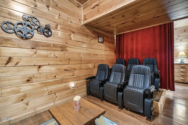 home theater room featuring wooden walls, wooden ceiling, and hardwood / wood-style floors