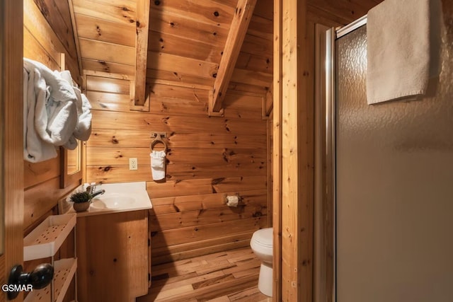 full bath with wood ceiling, wood walls, a shower stall, vanity, and toilet