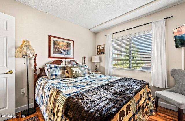 102 Baskins Creek Byp Unit 104, Gatlinburg, TN 37738 - bedroom with wood finished floors, baseboards, and a textured ceiling