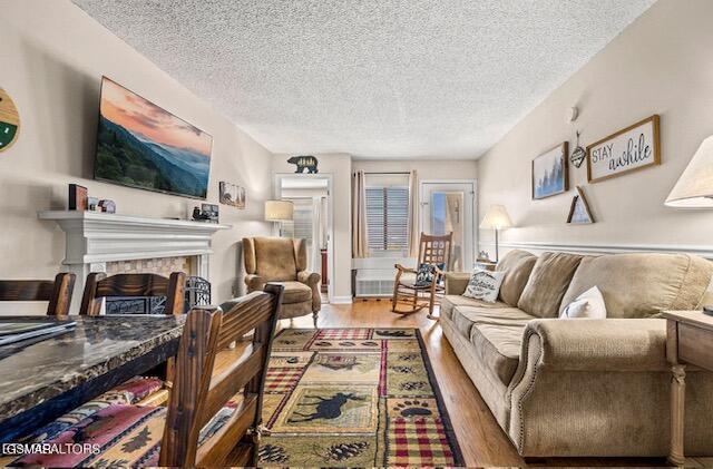 102 Baskins Creek Byp Unit 104, Gatlinburg, TN 37738 - living room featuring wood finished floors, a textured ceiling, and a fireplace