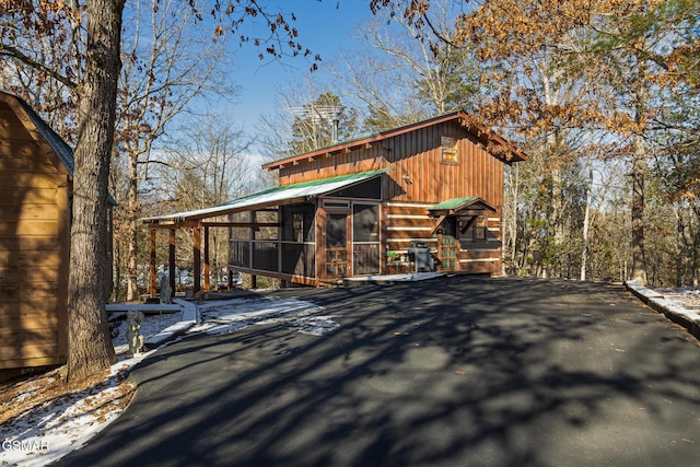 snow covered structure featuring a sunroom