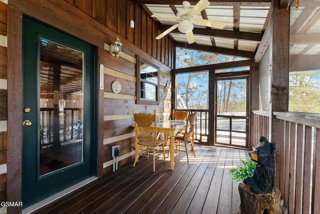 unfurnished sunroom featuring vaulted ceiling with beams and ceiling fan