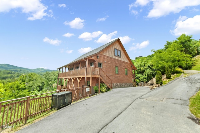 view of side of home featuring a deck with mountain view