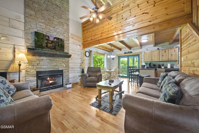 2126 Loafers Glory Way, Gatlinburg, TN 37738 - living area featuring wooden walls, ceiling fan, beam ceiling, a fireplace, and light wood-type flooring