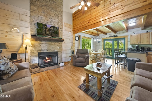 2126 Loafers Glory Way, Gatlinburg, TN 37738 - living room with beam ceiling, light wood finished floors, wood walls, a stone fireplace, and a ceiling fan