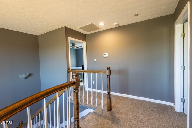 hallway with carpet floors and a textured ceiling