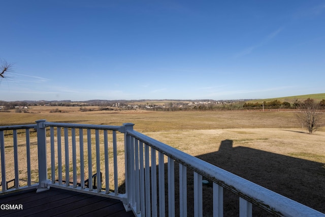 wooden deck featuring a yard and a rural view