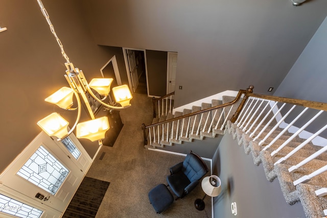 stairs with carpet floors and a high ceiling