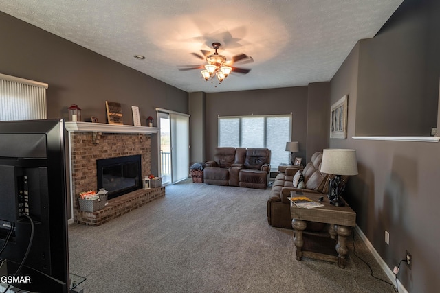 living room with ceiling fan, carpet floors, a fireplace, and a textured ceiling