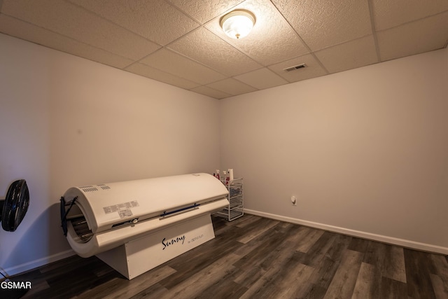 bedroom featuring a paneled ceiling and dark hardwood / wood-style floors