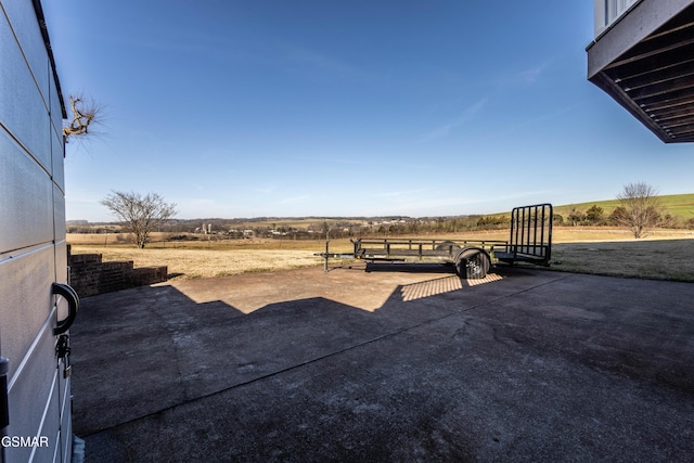 view of yard with a rural view and a patio area