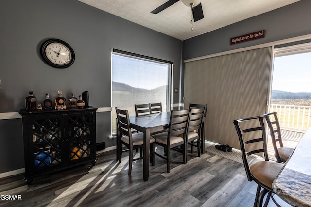 dining area with dark hardwood / wood-style floors and ceiling fan