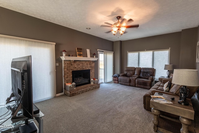 living room with ceiling fan, a brick fireplace, carpet, and a textured ceiling