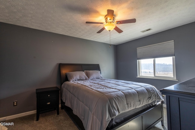 bedroom with ceiling fan, carpet flooring, and a textured ceiling