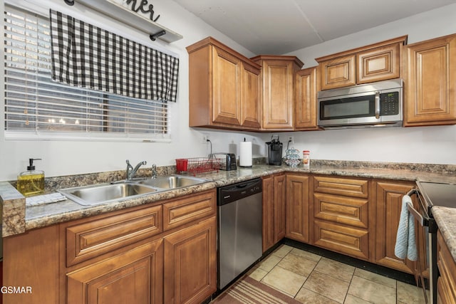 kitchen with light stone countertops, stainless steel appliances, and sink