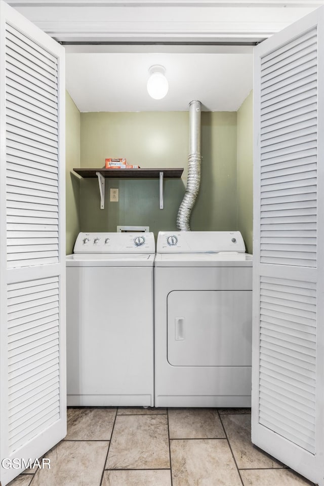 laundry room featuring washing machine and dryer and light tile patterned floors