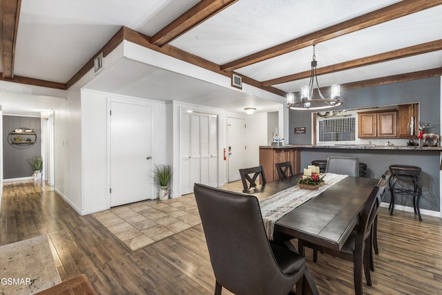 dining space with hardwood / wood-style floors, beam ceiling, and a chandelier