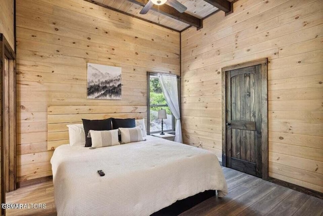 bedroom with beam ceiling, wood-type flooring, and wood walls