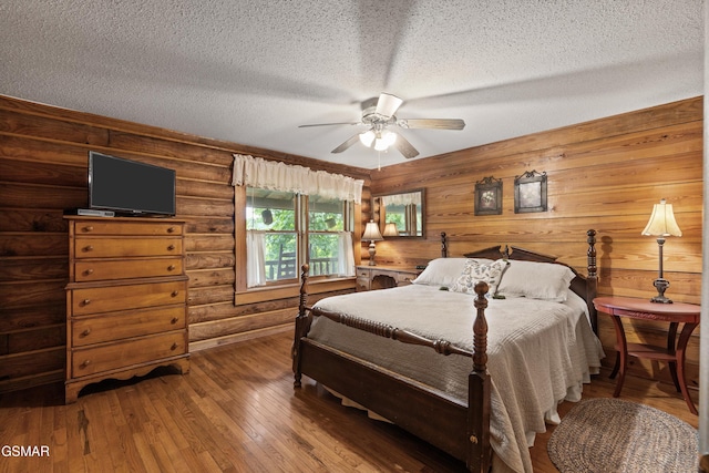 3114 Hatcher Top Rd, Sevierville, TN 37862 - bedroom featuring a textured ceiling, hardwood / wood-style flooring, a ceiling fan, and log walls
