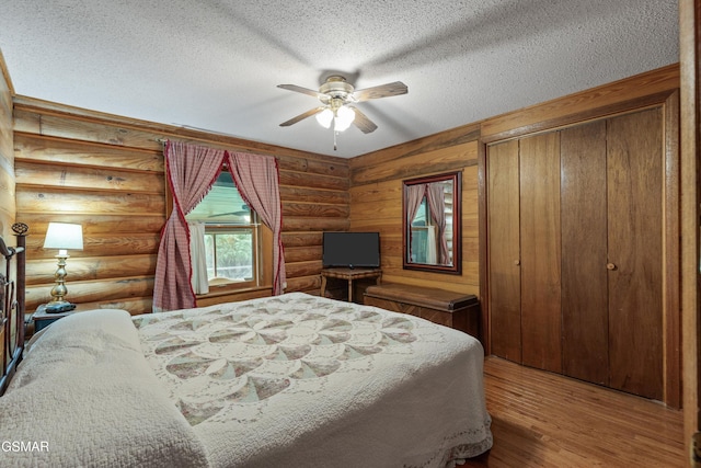 3114 Hatcher Top Rd, Sevierville, TN 37862 - bedroom with a textured ceiling, wood finished floors, log walls, a ceiling fan, and a closet