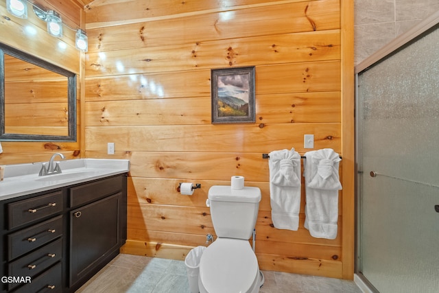 bathroom featuring wooden walls, a shower with door, vanity, and toilet