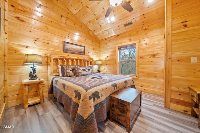 bedroom featuring hardwood / wood-style floors, wooden walls, vaulted ceiling, ceiling fan, and wood ceiling