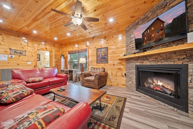 living room with ceiling fan, light wood-type flooring, wooden ceiling, and a fireplace