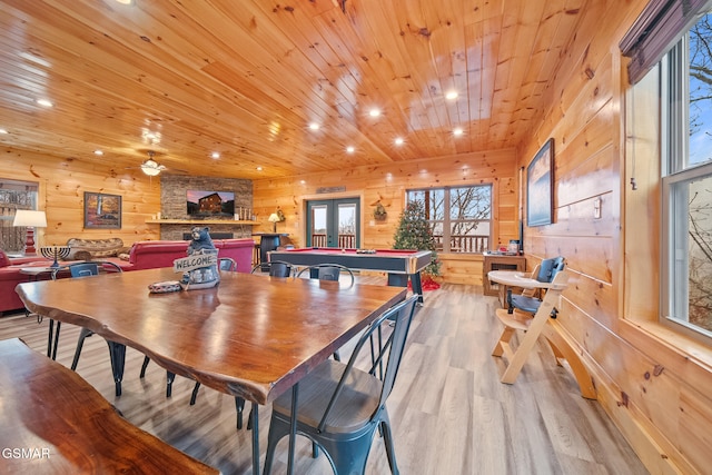 dining room featuring wooden walls, light hardwood / wood-style floors, wooden ceiling, and billiards