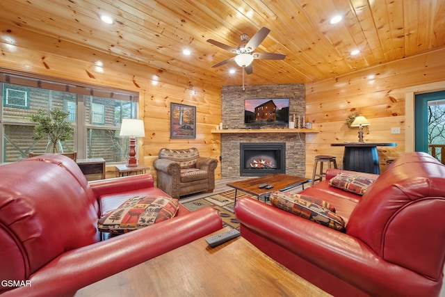 living room with ceiling fan, wooden ceiling, wood walls, hardwood / wood-style floors, and a fireplace