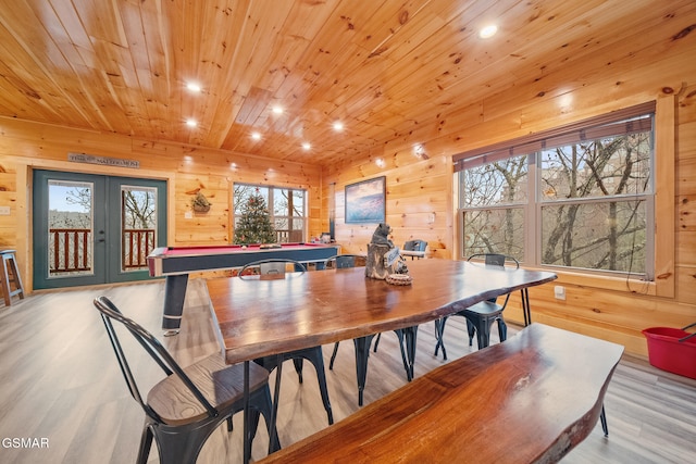 dining space featuring french doors, light hardwood / wood-style flooring, a healthy amount of sunlight, and wood ceiling