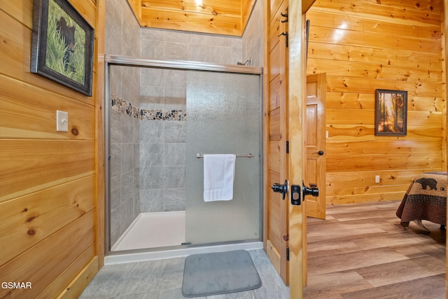 bathroom with an enclosed shower and wooden walls