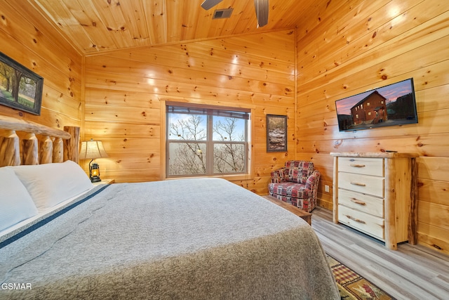 bedroom with ceiling fan, wooden walls, wooden ceiling, and vaulted ceiling