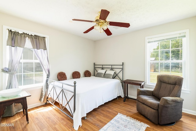 bedroom featuring baseboards, a ceiling fan, and wood finished floors