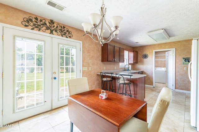 dining room featuring visible vents, washer / dryer, light tile patterned flooring, a textured ceiling, and french doors