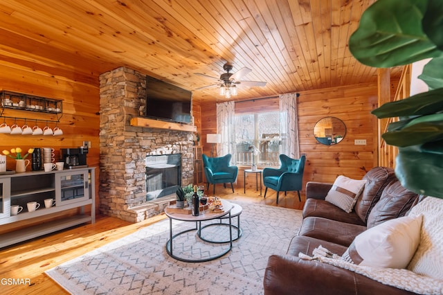 410 Oak Sky Way, Sevierville, TN 37876 - living area featuring wooden walls, wooden ceiling, a stone fireplace, wood finished floors, and ceiling fan