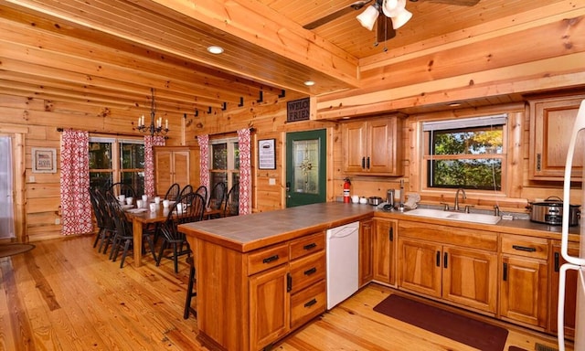 kitchen with kitchen peninsula, light wood-type flooring, ceiling fan with notable chandelier, white dishwasher, and sink