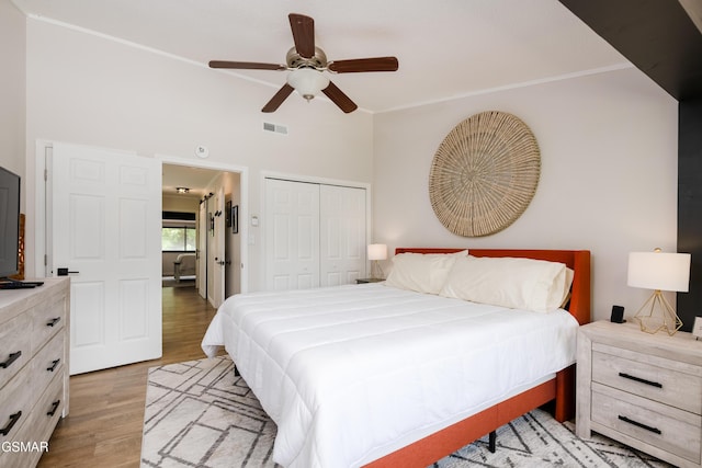 bedroom with visible vents, a ceiling fan, light wood-style floors, and a closet