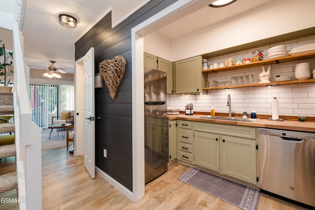 bar with tasteful backsplash, freestanding refrigerator, light wood-style floors, dishwasher, and a sink