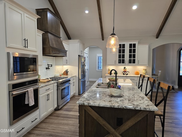 708 Lakeside Ct, Dandridge, TN 37725 - kitchen with stainless steel appliances, arched walkways, a sink, a kitchen breakfast bar, and glass insert cabinets