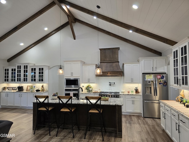 708 Lakeside Ct, Dandridge, TN 37725 - kitchen with appliances with stainless steel finishes, premium range hood, wood finished floors, white cabinets, and decorative backsplash