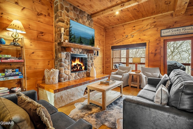 living room with wooden ceiling, a stone fireplace, wooden walls, hardwood / wood-style flooring, and beam ceiling