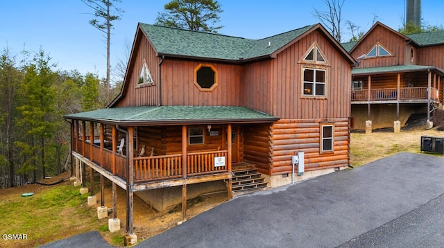 log cabin with crawl space, a shingled roof, central air condition unit, a porch, and log exterior