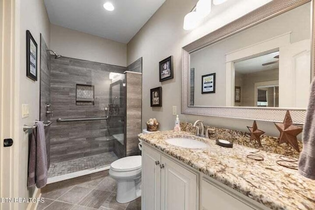 bathroom with toilet, tile patterned flooring, walk in shower, and vanity